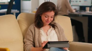 Müdür hanım tablette oturuyor rahat koltukta oturuyor gülümsüyor.