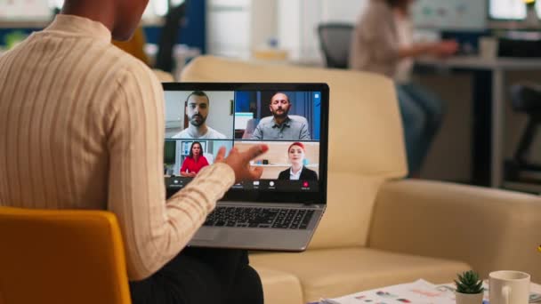 Over de sholder shot van werknemer praten met partners met behulp van video call — Stockvideo