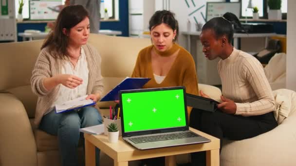 Diverse vrouwen zitten aan tafel bespreken strategie met groene scherm laptop — Stockvideo