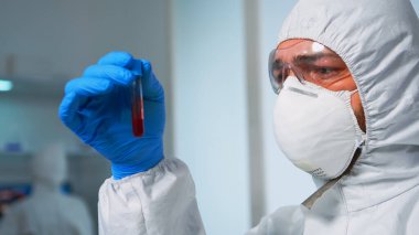 Laboratuvarda kan tahlil tüplerini inceleyen bir bilim adamı.