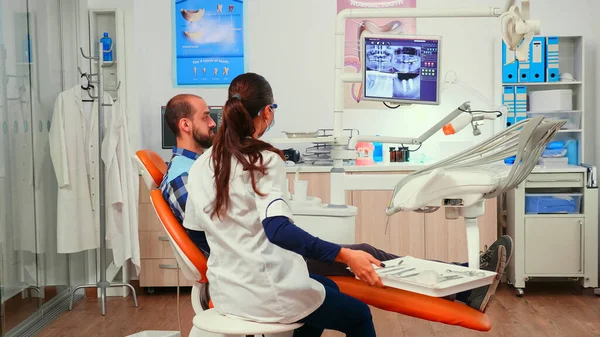 Orthodontist discussing MRI scan with patient before surgery