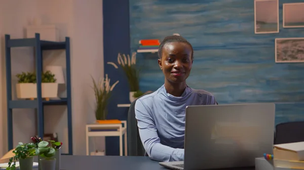 Afro-Amerikaanse vrouw kijken naar camera glimlachen werken op pc — Stockfoto