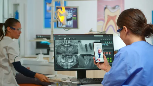 Sjuksköterska som har videosamtal med sakkunnig stomatologisk läkare — Stockfoto