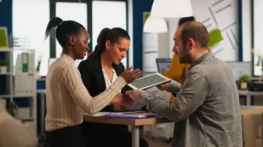 Yıllık mali raporları okuyan coşkulu iş adamları masada oturuyorlar.