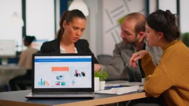 İş kadını dizüstü bilgisayar kullanarak finansal projeden bahsediyor.