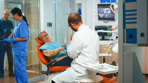 牙科医生用下颌骨的石膏模型解释手术 — 图库照片