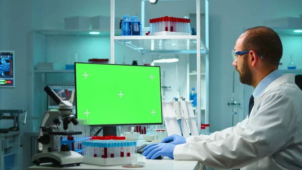 Доктор працює на комп'ютері з зеленим екраном з плином часу — стокове фото