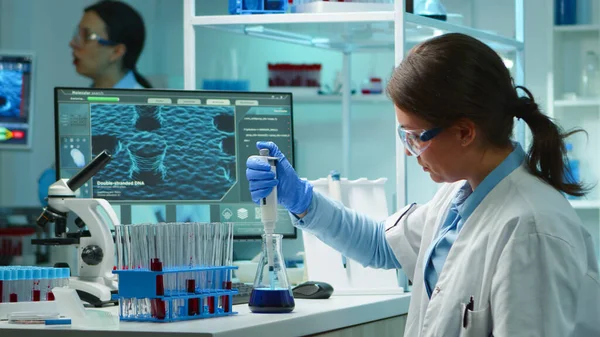 Scienziato donna pipettatura liquido per testare la provetta — Foto Stock