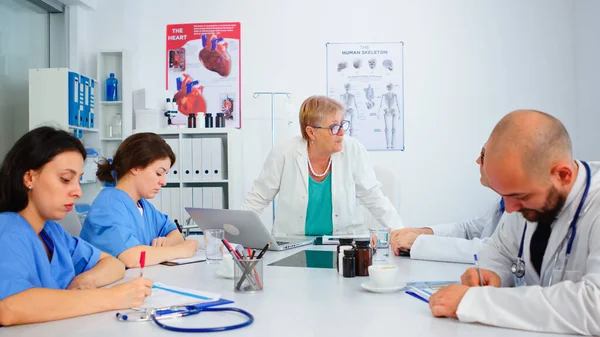 Femme médecin senior debout devant des collègues présentant un diagnostic — Photo