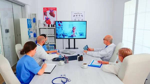 Groupe de médecins discutant avec le médecin expert lors de la vidéoconférence — Photo