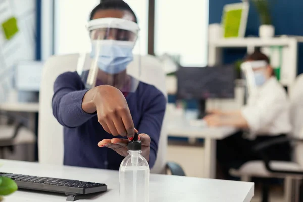 Primer plano de la mujer africana usando desinfectante de manos durante la pandemia mundial —  Fotos de Stock