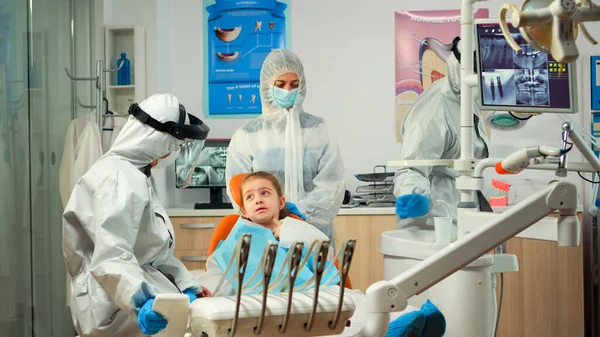 Team stomatologico in tuta protettiva per la preparazione di utensili sterilizzati dentali — Foto Stock