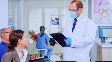 Doktor hasta diş sorunları hakkında not alıyor.