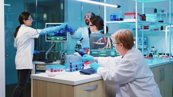 현미경을 사용하여 태블릿 컴퓨터와 화학자를 들고 있는 간호사 — 스톡 사진