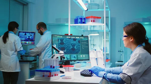 Хімічна медсестра сидить у науковій лабораторії, вивчаючи еволюцію вірусів — стокове фото