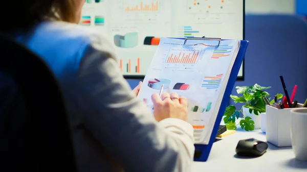 Primer plano de la mujer de negocios sosteniendo portapapeles con gráficos — Foto de Stock