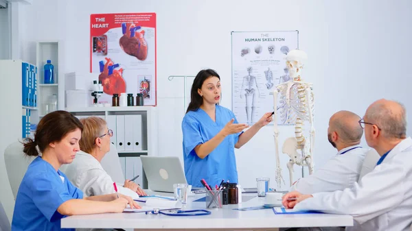 Doctor beschrijft de lay-out van de menselijke wervelkolom in het bijzijn van collega 's — Stockfoto