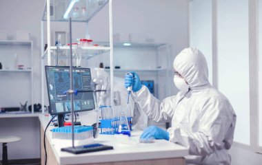 Laboratuar bilimcisi numune incelerken mikro pipet kullanır.