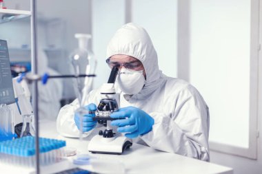 Mikrobiyolog yüksek teknolojili mikroskop kullanarak virüs evrimini inceliyor.