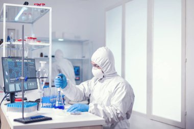 Otomatik pipetle çalışan bir sağlık uzmanı.
