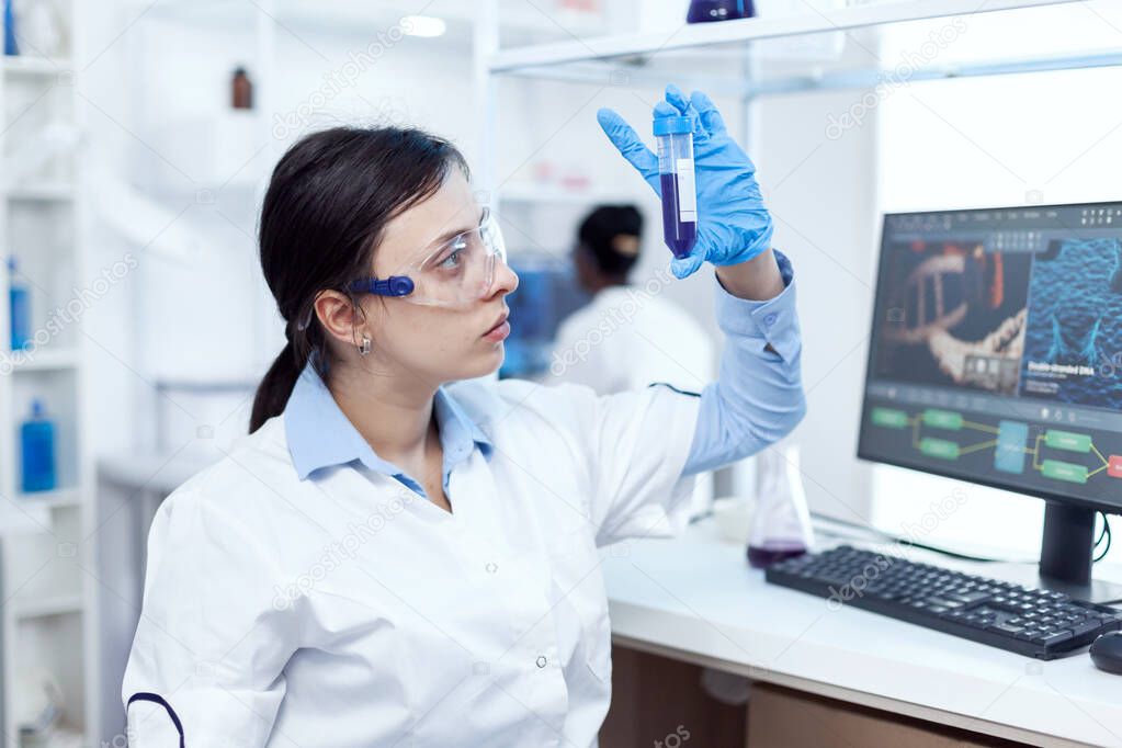 Close up of young doctor in biochemistry analysing genetic material.