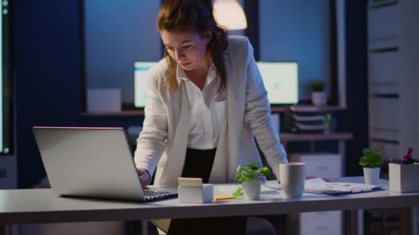 Geschäftsfrau blickt nach Tippen auf Laptop lächelnd in die Kamera — Stockvideo