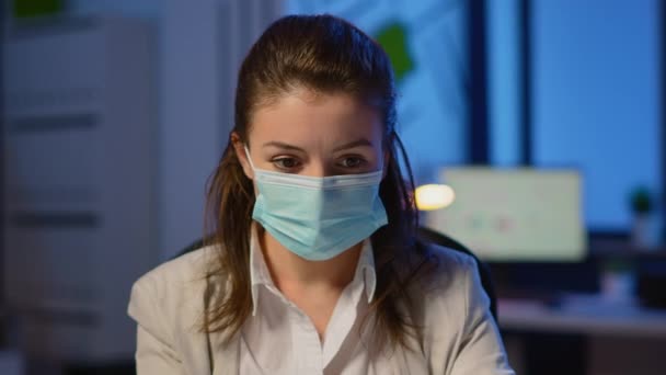 Close up of woman with face mask reading emails late at night — Stock Video