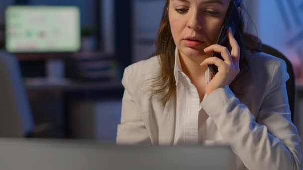 Fáradt szabadúszó nő beszél telefonon munka közben — Stock videók