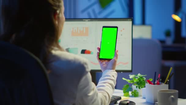 Geschäftsfrau blickt auf Green Screen Monitor ihres Smartphones — Stockvideo