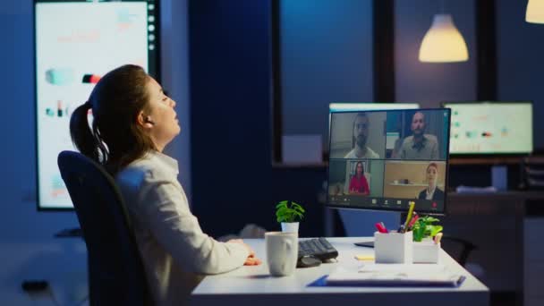 Mujer de negocios hablando durante la videoconferencia con el equipo en la medianoche — Vídeos de Stock