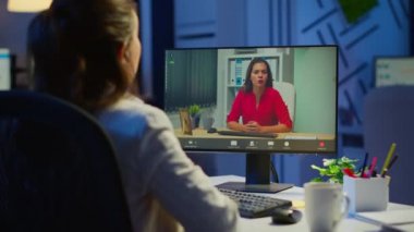 Müdür, gece yarısı video konferansı sırasında iş arkadaşıyla konuşuyor.