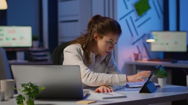 Manager woman using laptop and tablet in same time working overtime — Stock Video