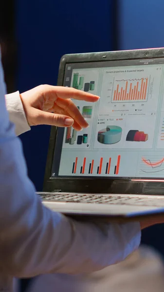 Взгляд деловой женщины, анализирующей финансовую статистику с ноутбуком — стоковое фото