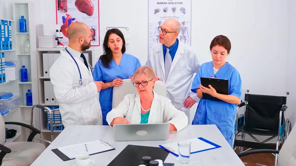 Médico especialista maduro informando a su equipo médico en la sala de conferencias — Foto de Stock