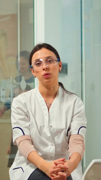 Kobieta stomatolog mówi przez kamerę wideo — Zdjęcie stockowe