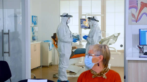 Lékaři v uniformě plné ochrany proti virům mluví v chirurgickém sále — Stock fotografie