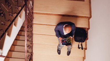 Mutsuz kovulmuş girişimci merdivenlerde oturuyor.