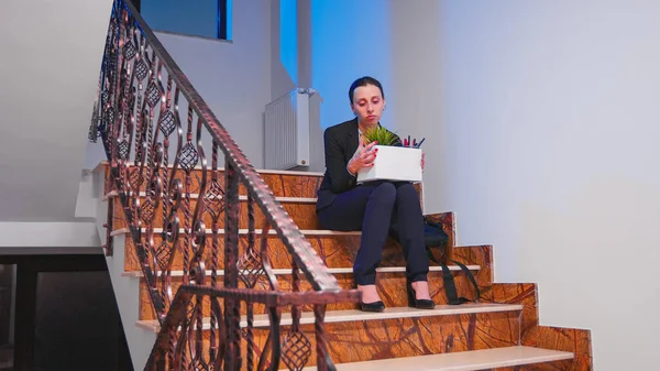 Unemployed businesswoman holding box of stuff