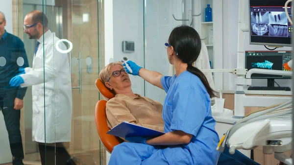 Nusre misst Temperatur einer alten Frau vor der Zahnuntersuchung — Stockfoto