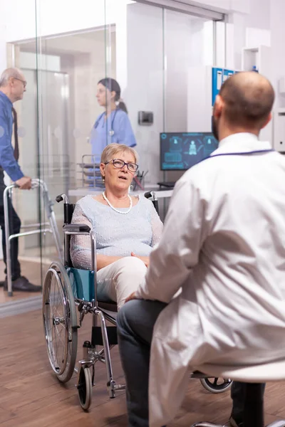 Verlamd discussiëren met geriater in rolstoel — Stockfoto