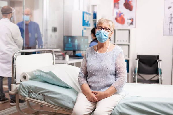 Senior woman waiting for doctor consultation in hospital — Stock Photo, Image