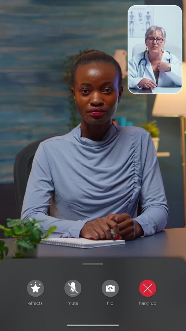 Vertikální video: Africká dáma mluví online s lékařem dělat si poznámky — Stock video