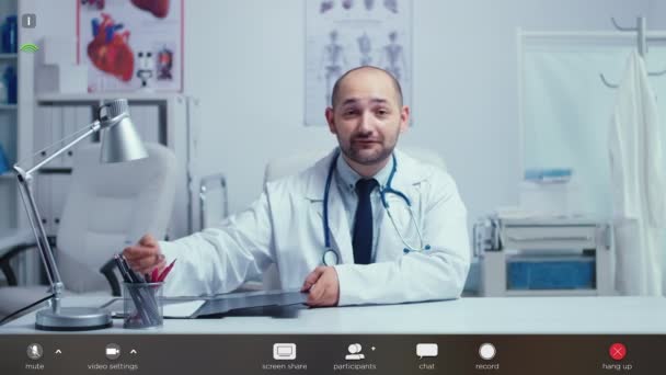 Практикующий врач предлагает медицинский онлайн-совет из своего офиса — стоковое видео