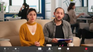 Video konferansı sırasında web kamerası kullanarak iş arkadaşlarıyla konuşuyor