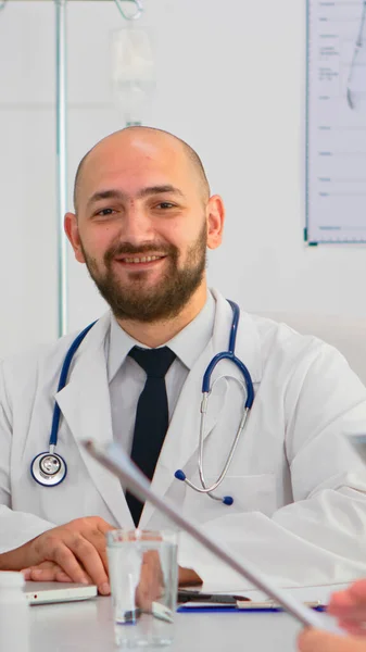 Doctor in lab coat and stethoscope looking at camera smiling — Stock Photo, Image