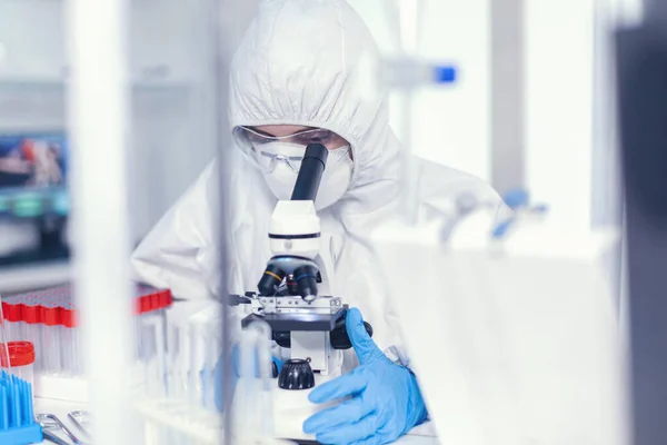Scienziato in tuta protettiva sterile che analizza il coronavirus — Foto Stock