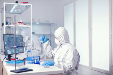 Tıp bilimcisi numuneyi otomatik pipetle hazırlıyor.