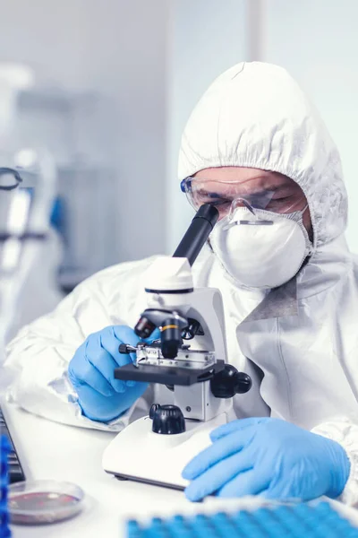 Medicinsk ingenjör justerar mikroskop bär ppe — Stockfoto