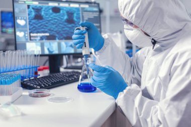 Mikrobiyoloji laboratuvarındaki adam petri kabını tutuyor.