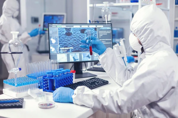 Científico en el laboratorio scienec examinando tubos de análisis de sangre —  Fotos de Stock